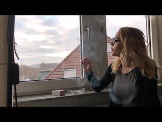 yt5s.io-striking woman smokes by a window